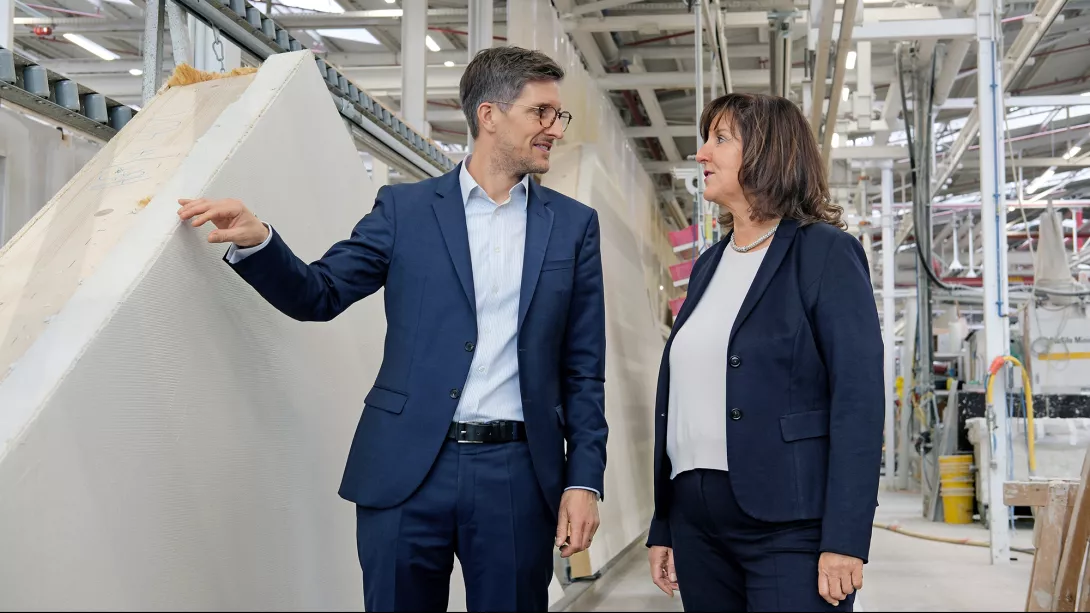 Manuel Schönwitz im Gespräch mit Heidi Weber-Mühleck im Bereich der stehenden Wandfertigung. Die innovative, nachhaltige Gebäudehülle der Weber-Häuser zeichnet sich durch hervorragende energetische Werte aus. Das sorgt zu jeder Jahreszeit für ein angenehmes Wohnklima. 
